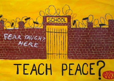 Fear Taught Here is painted on a brick wall in front of a school, Words Teach Peace? is below