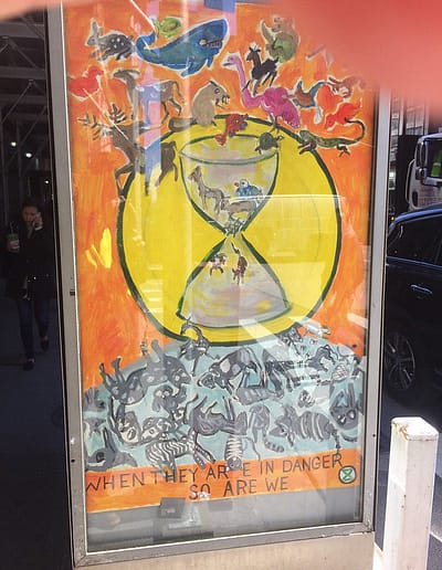 Ad box poster shows an hour glass with animals falling through to extinction and the text, "when they are in danger so are we."