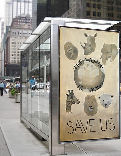 Pictures of animals surround a dying world with a plea, "Save Us". the poster is in a city bus shelter ad box.