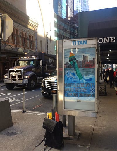 Ad box on a city street with ARRT! poster promoting environmental message.