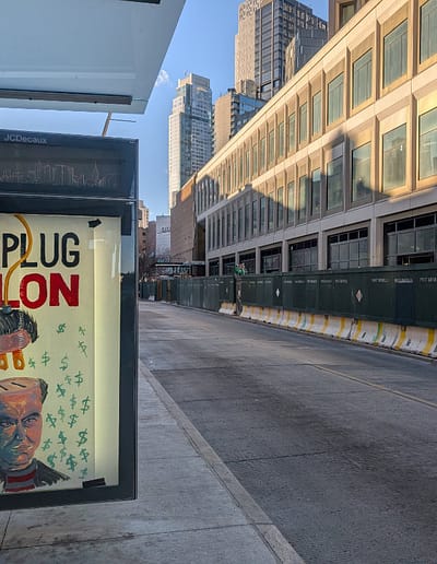 poster on street shows head of a man with top half unplugged.
